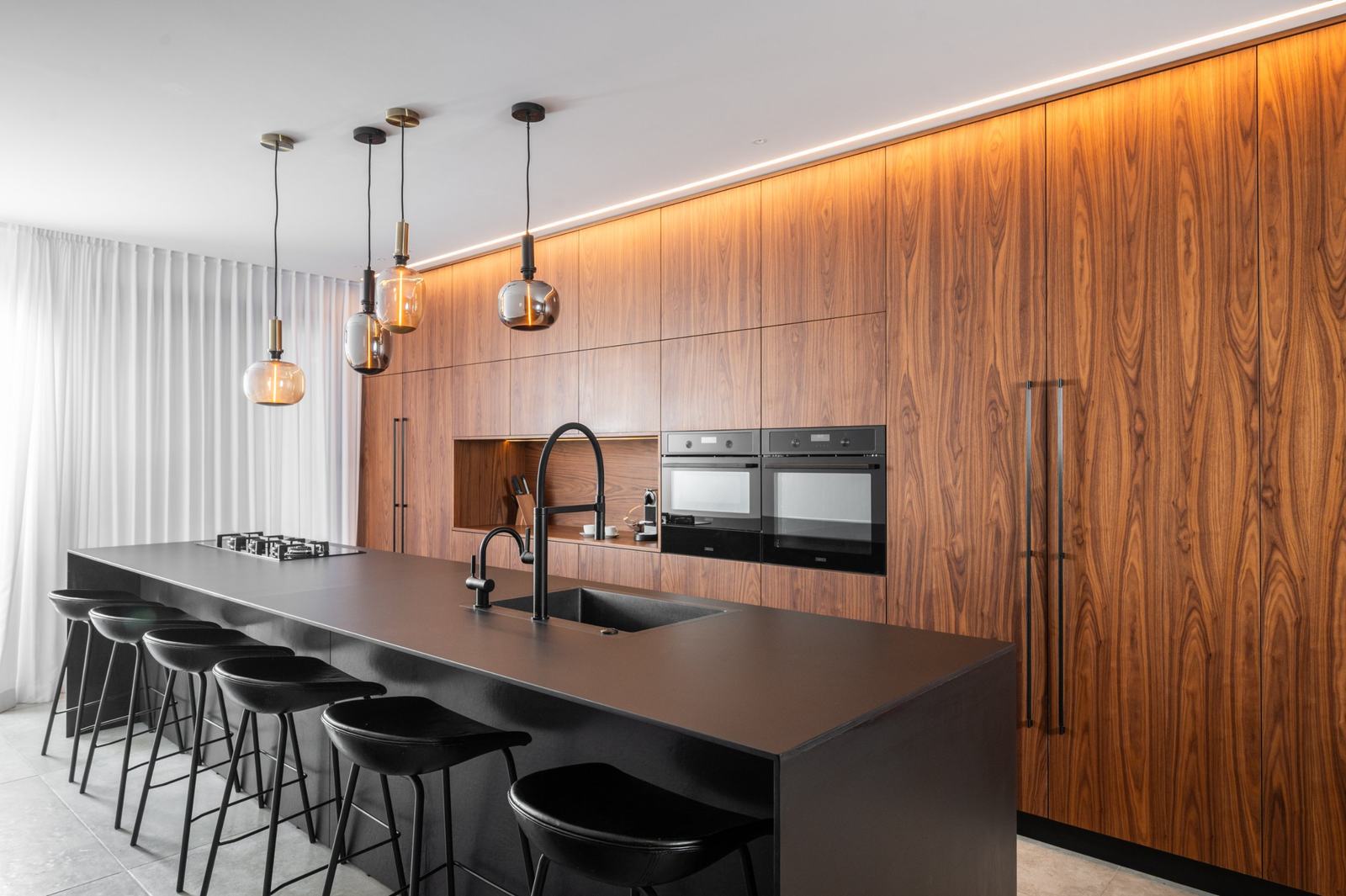 Walnut kitchen wall with a black island